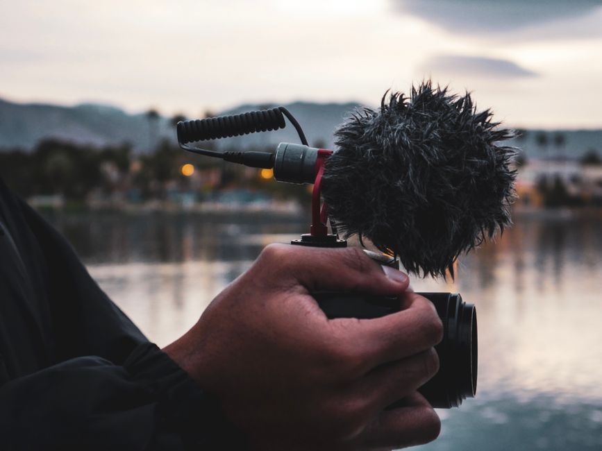 A creator filming with a clip-on wireless microphone