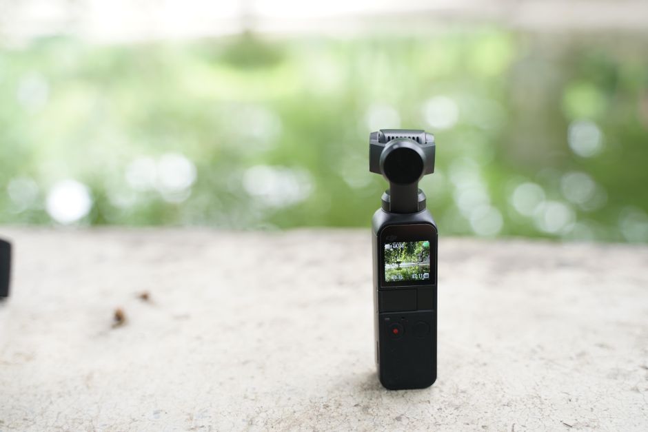 Pocket gimbal camera standing on a concrete ledge outdoors