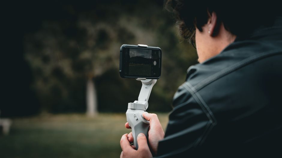 Smartphone gimbal stabiliser held while shooting video